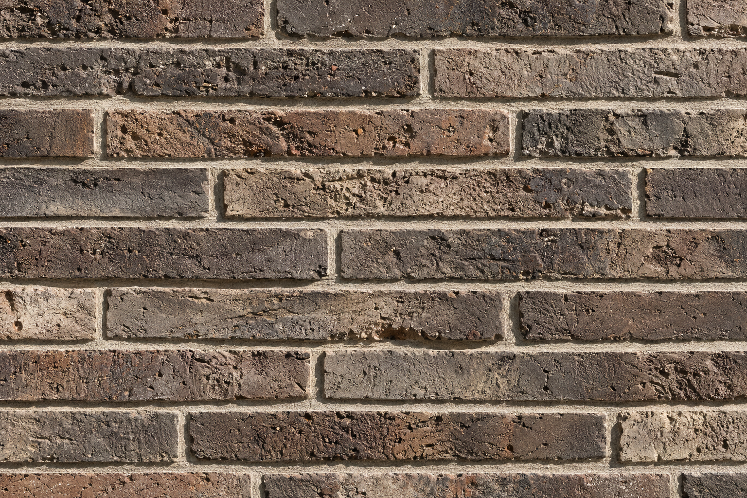 Close-up of long, textured grey and brown brick masonry at the Kolumba Museum Cologne.