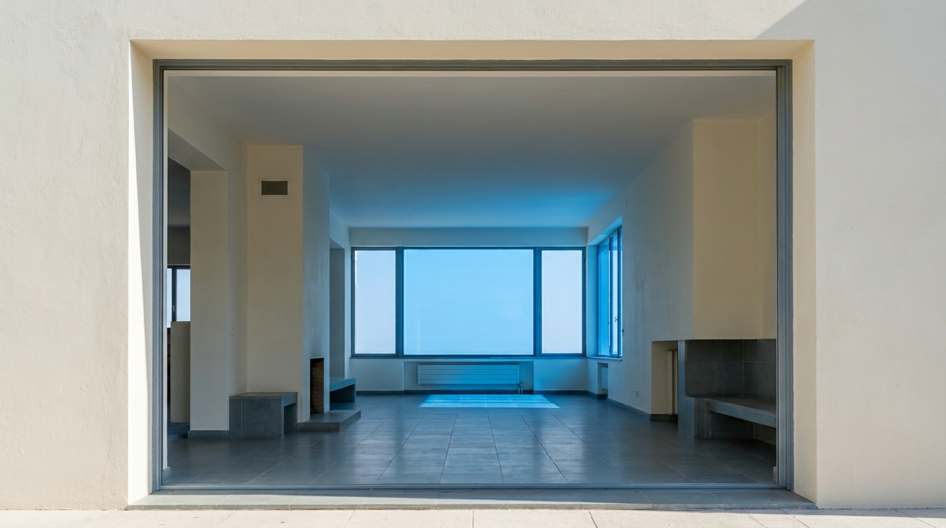 Interior of Villa Noailles at dusk, showing warm lamplight from within a cubist living space with smooth plaster walls and clean lines.